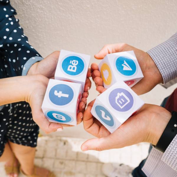 Four hands holding cubes with social media icons_ Facebook, Twitter, Instagram Four hands holding cubes with social media icons_ Facebook, Twitter, Instagram