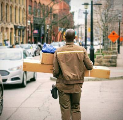 person carrying packages on a bustling city street person carrying packages on a bustling city street